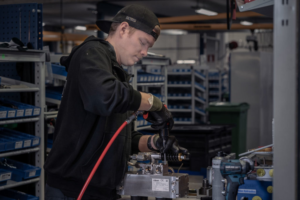 un employé DYNASET, Kalle Vaskelainen, qui assemble une pompe à eau à haute pression hydraulique DYNASET HPW sur son poste de travail.