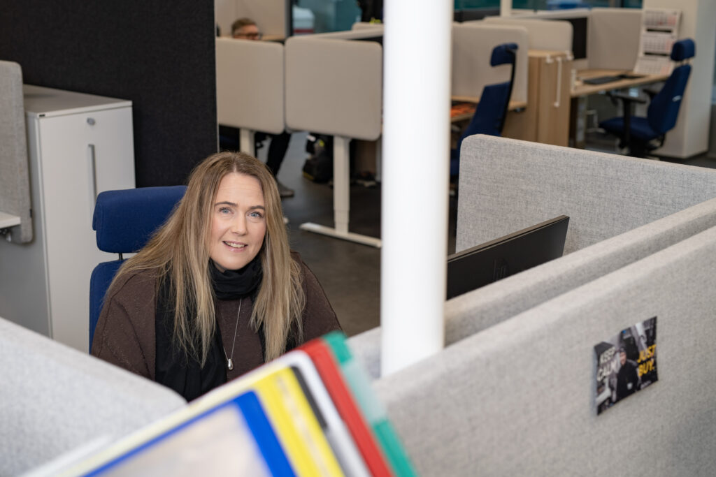 Elina Raesola working at her desk in the open-plan office