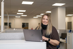 Elina Raesola working on a laptop at the DYNASET office.